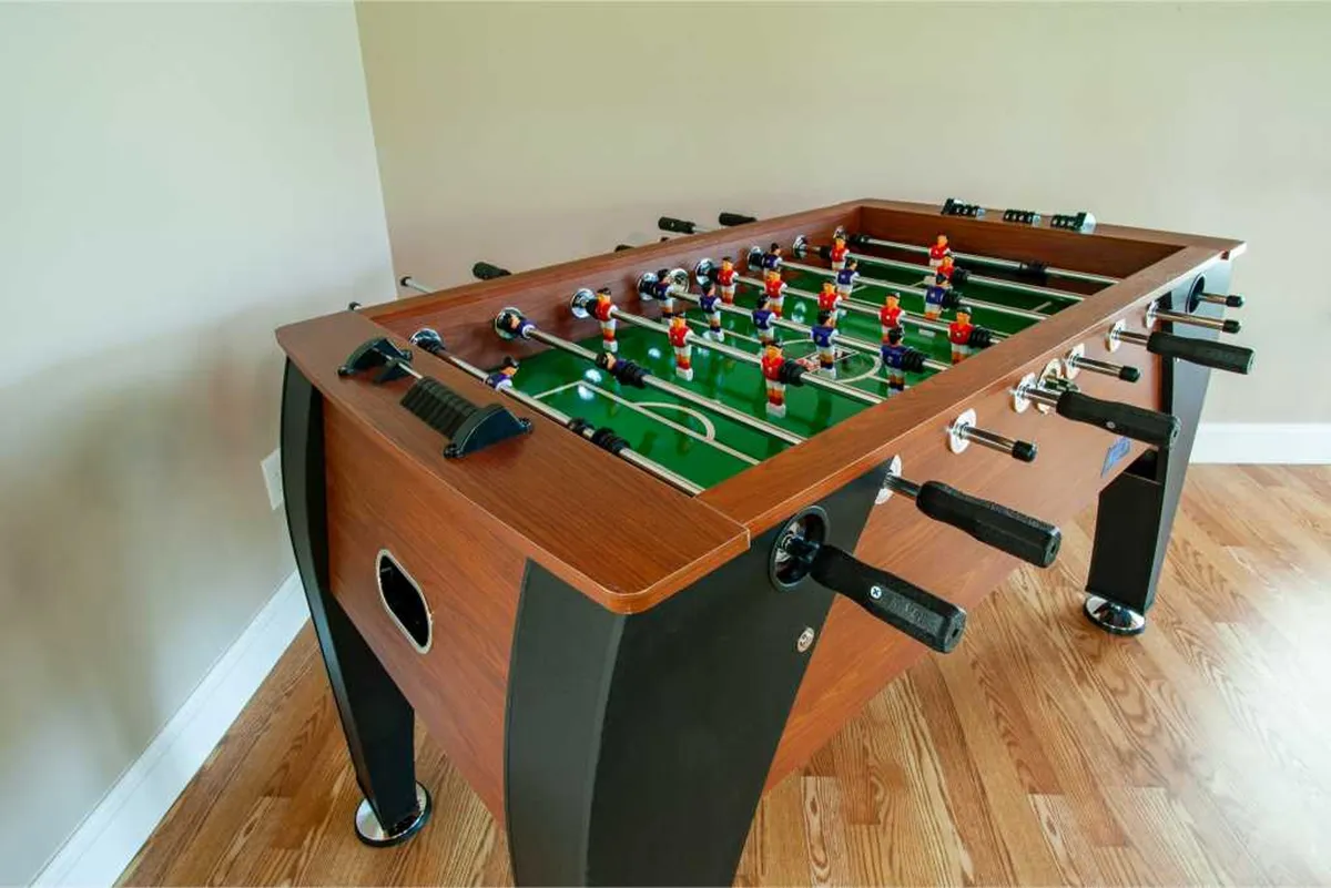 A close-up view of a foosball table with colorful player figures and rich wooden textures, capturing the excitement of game nights and interactive fun.